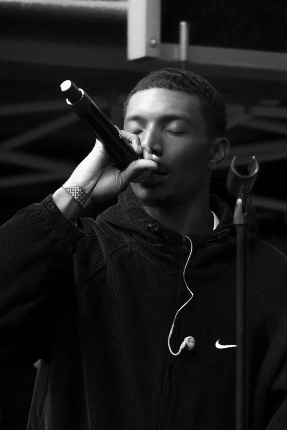 a singer with eyes closed, mic to his lips, in black and white