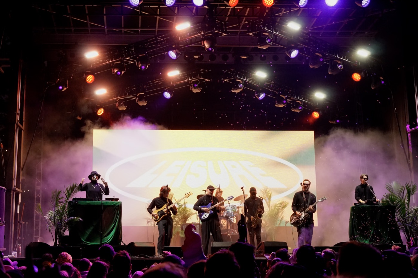 a seven-piece band playing under purple and orange stage lights